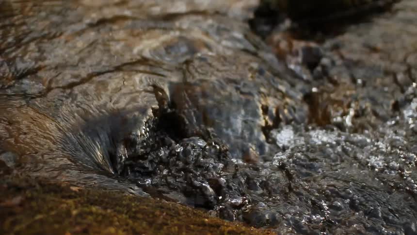 Water is flowing over rocks into a river