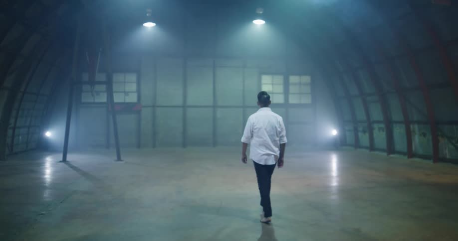 Man walks barefoot into empty building and stands looking around