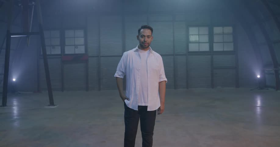 A man stands in a building and smiles