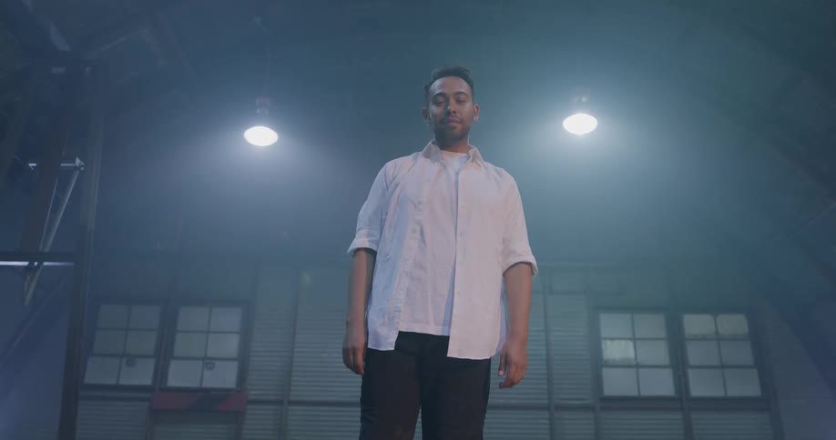 Hispanic man inside warehouse stands in front of the camera