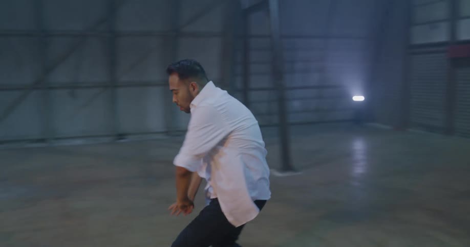 Stubbly bearded man dances indoors