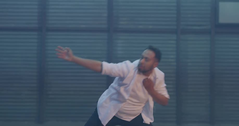 A man performing a dance in a dim room