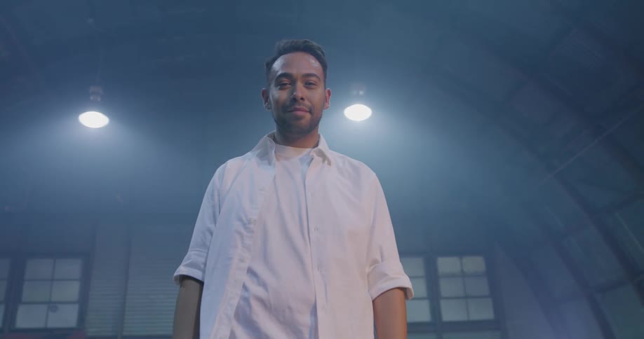 A man in a white shirt walking up and staring