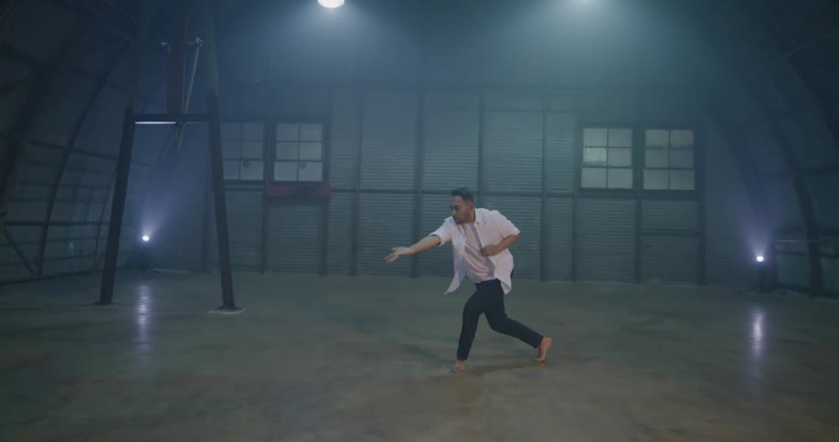 A man in a white shirt and black pants dancing