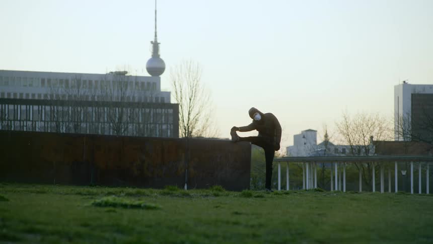 A person in a medical mask stretches
