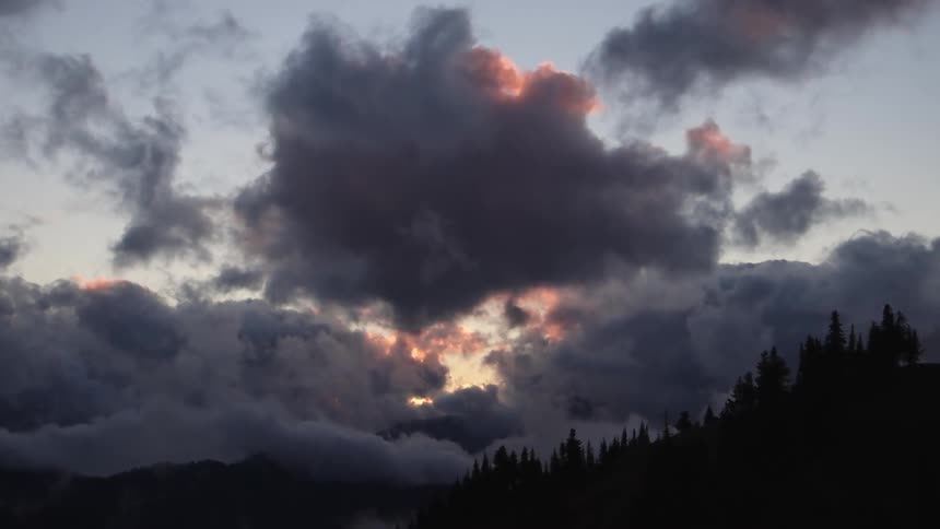 A view of the sky over some mountains at sunrise
