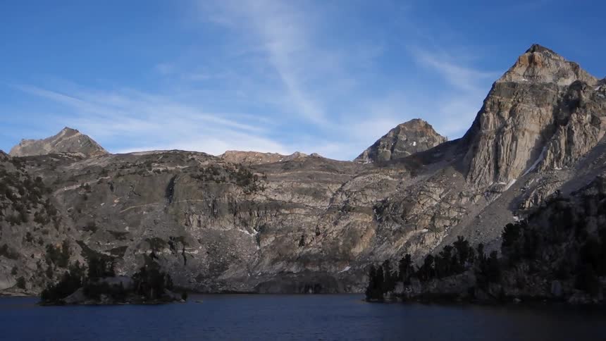 A body of water at the foot of rocky cliffs