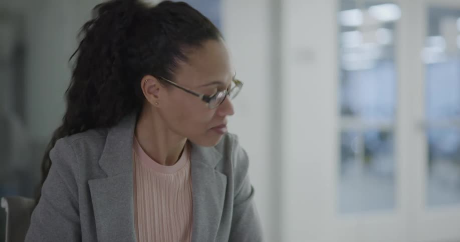 Businesswoman sittin at the table talks to the coworkers in the office