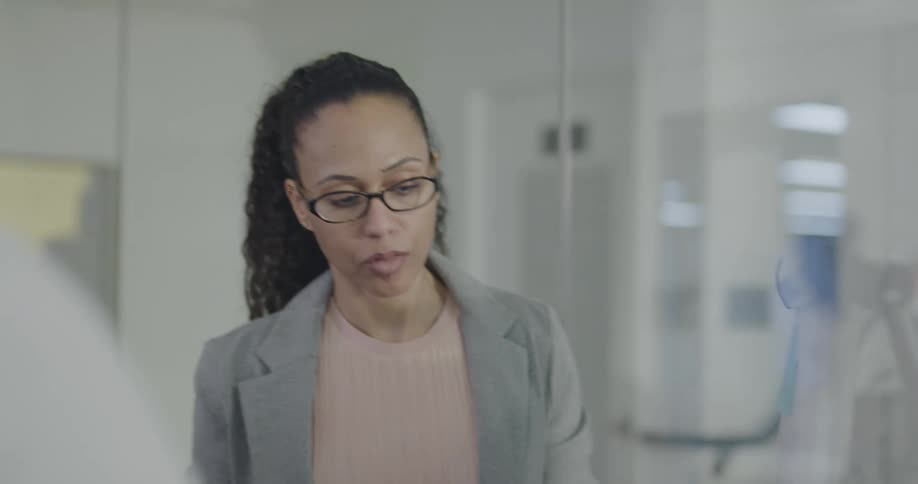Two women discussing a whiteboard