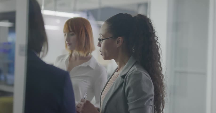 Three women in an office brain storm together