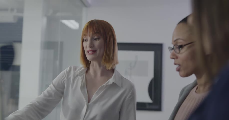 Three women brainstorm in an office