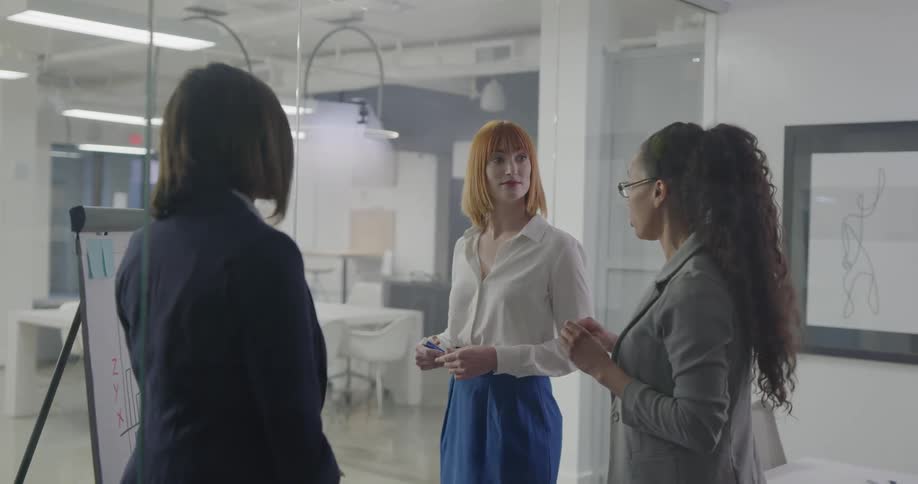Three women brainstorm in a conference room
