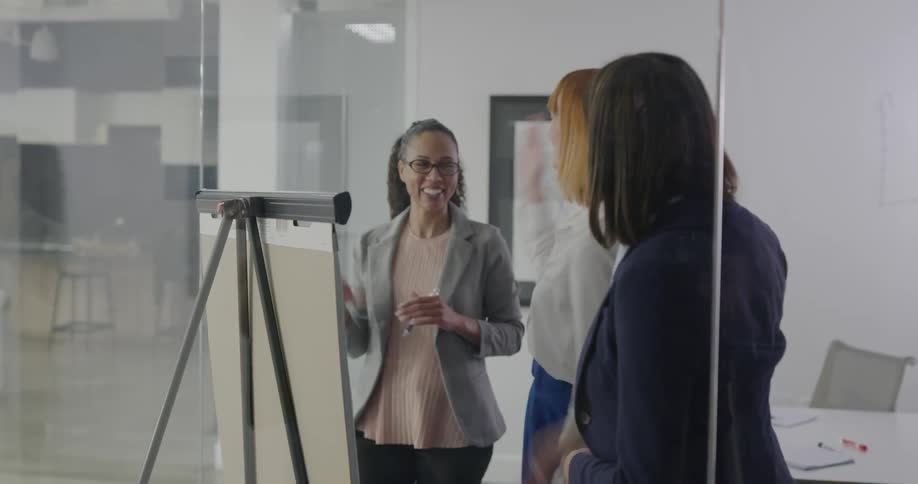Businesswomen rejoice and bump hands in the office