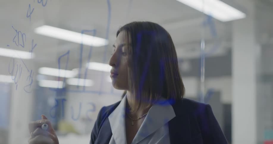 A woman works through a problem on the board