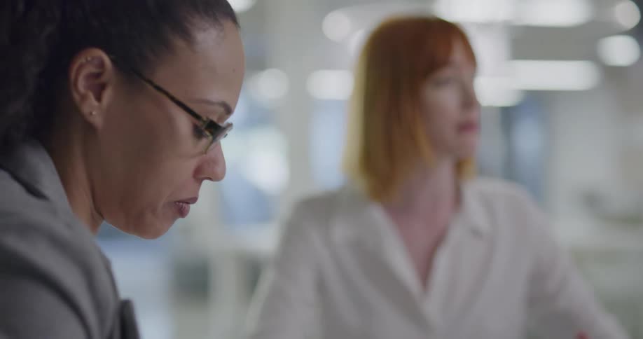 Businesswomen sitting at the table conduct a business meeting in the office