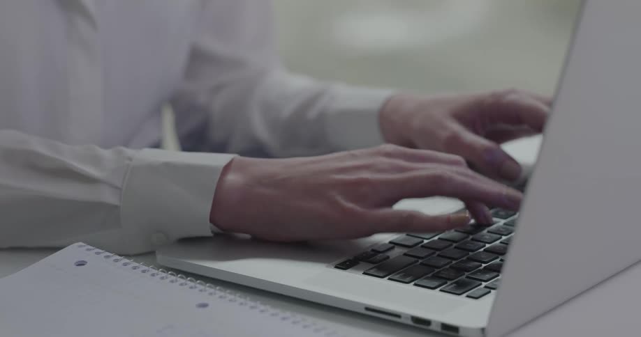 A woman types on her laptop