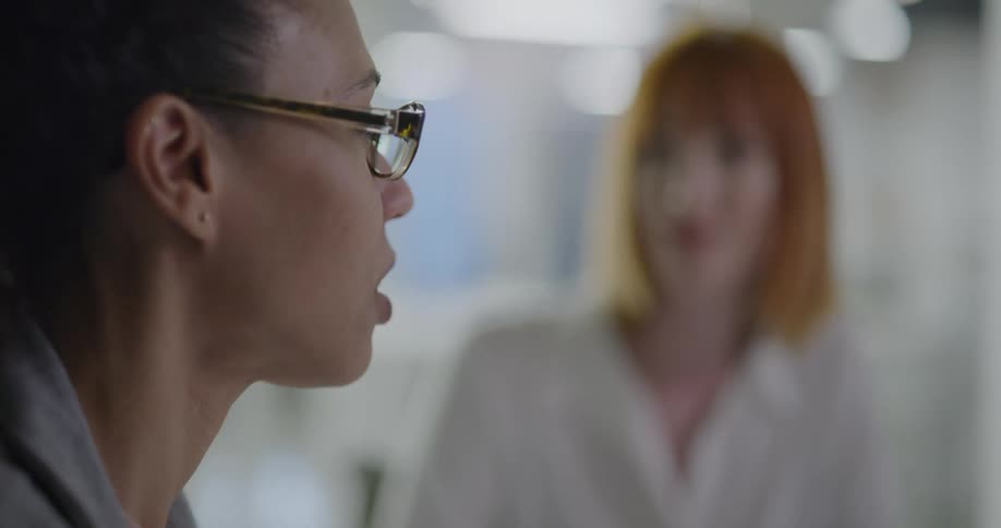 Two women sitting in an office talking