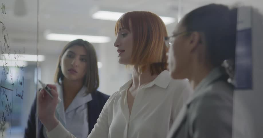 Three women brain storm in an office together