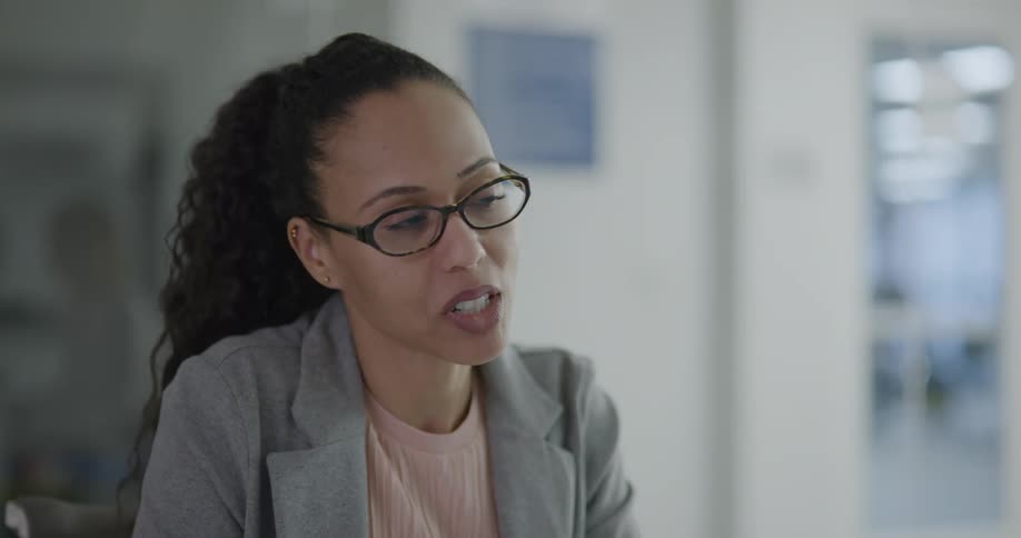 A woman in an office talks with others and then high fives them