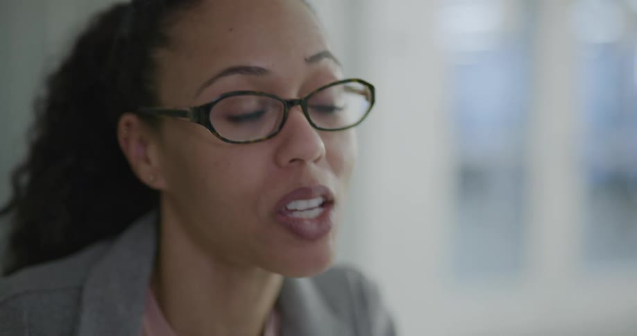 A woman in an office talks to others