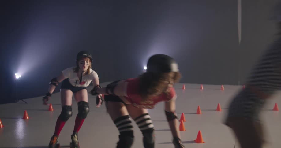 Women roller skate around the rink