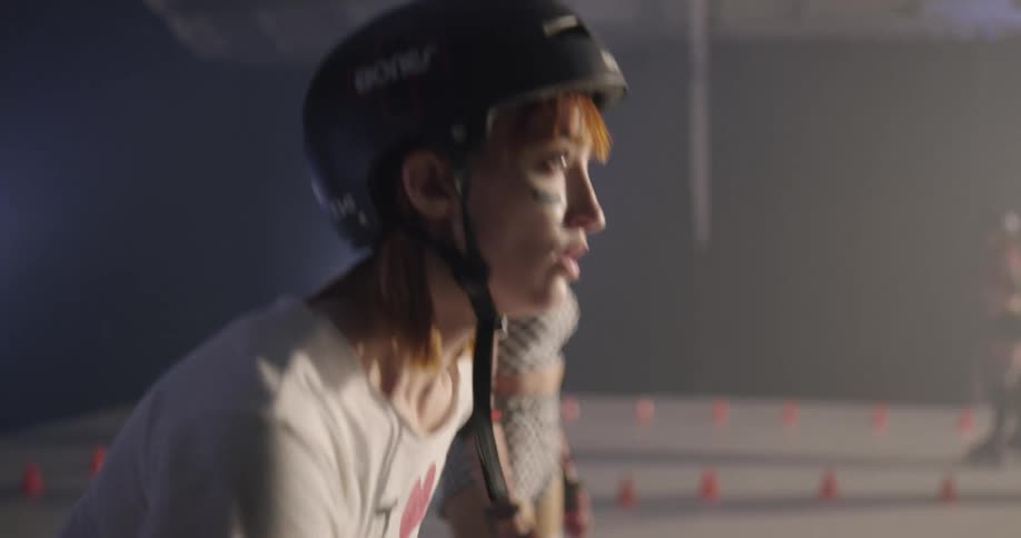 Women with helmets and gloves racing on roller skates