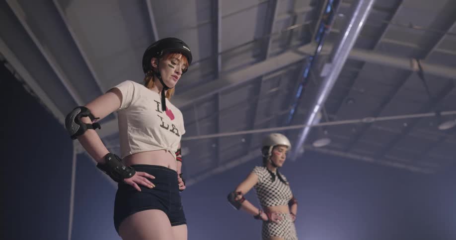 Two women in protective gear talk to one another