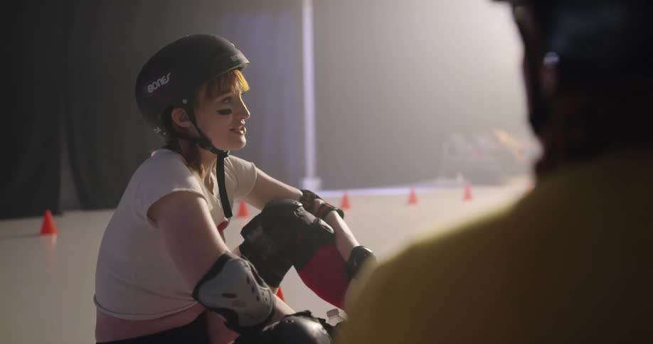 Women sitting and talking with elbow pads gloves and helmets