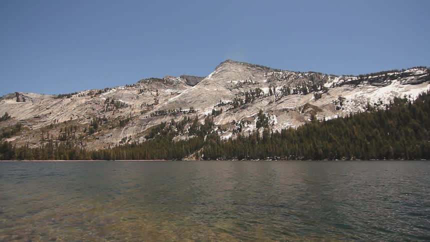 A lake flows in front of a mountain