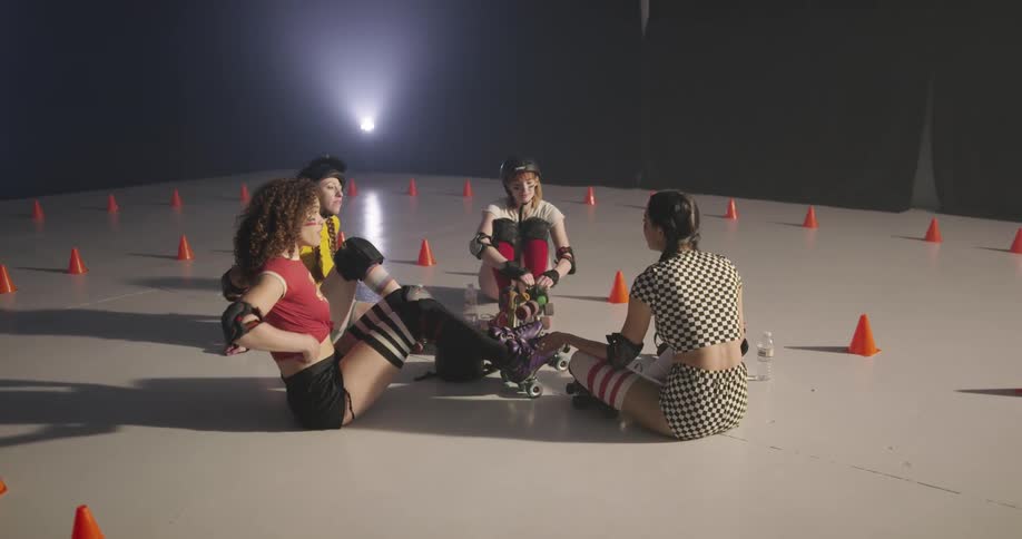 Women with roller skates sitting on the floor and talking