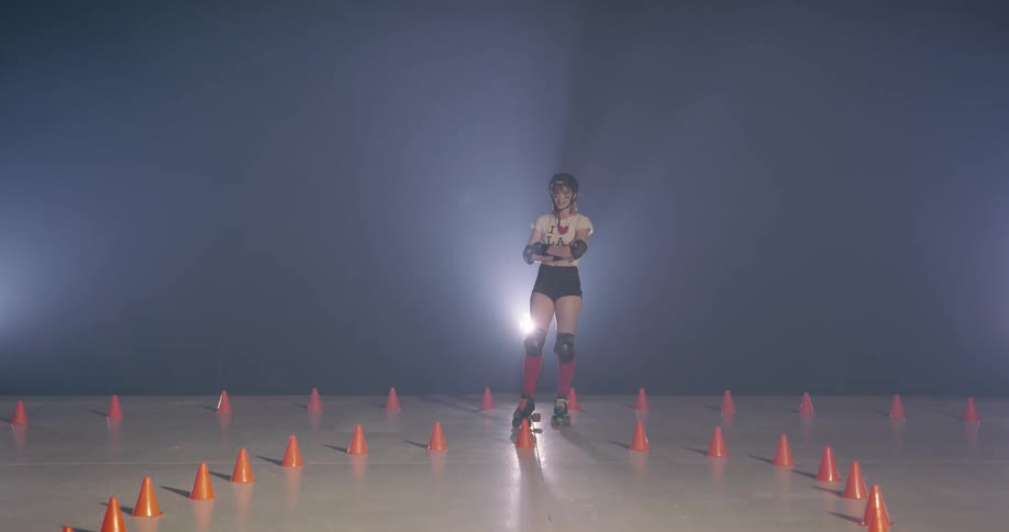 A teen in a helmet and wearing rollerskates poses for a camera