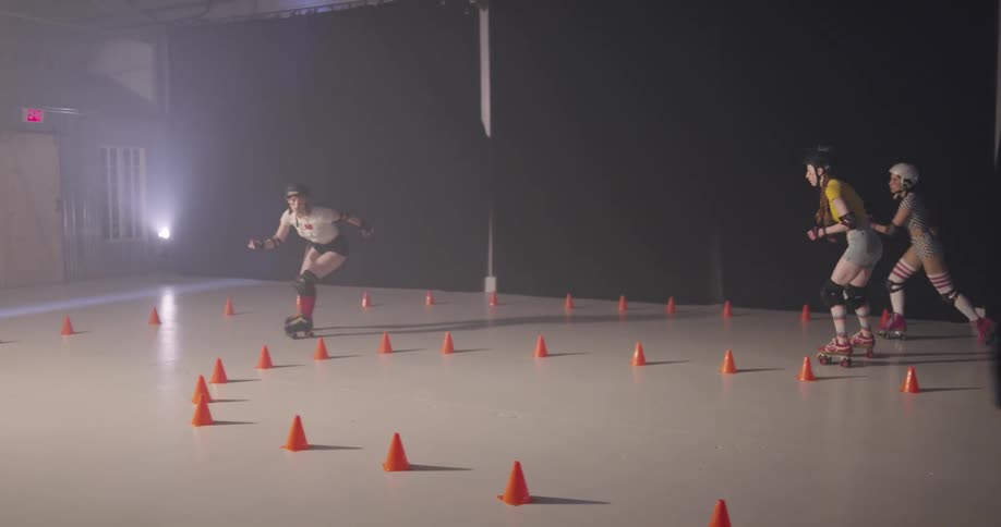 Women on roller skates skating and racing indoors in a circle