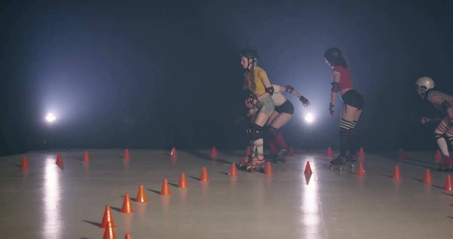 Women roller skating around cones