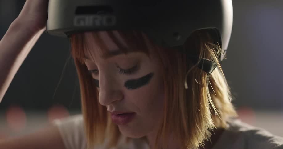 A white female adjusts her helmet