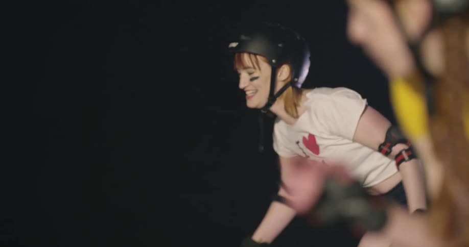 Women with helmets roller skating indoors