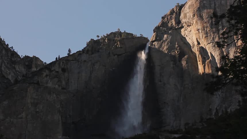 A waterfall cascades over a tall cliff