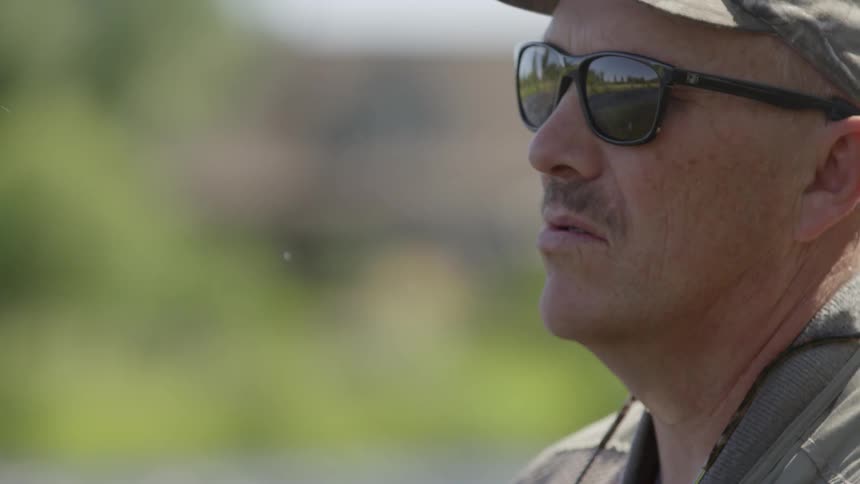 A man wearing sunglasses fishes