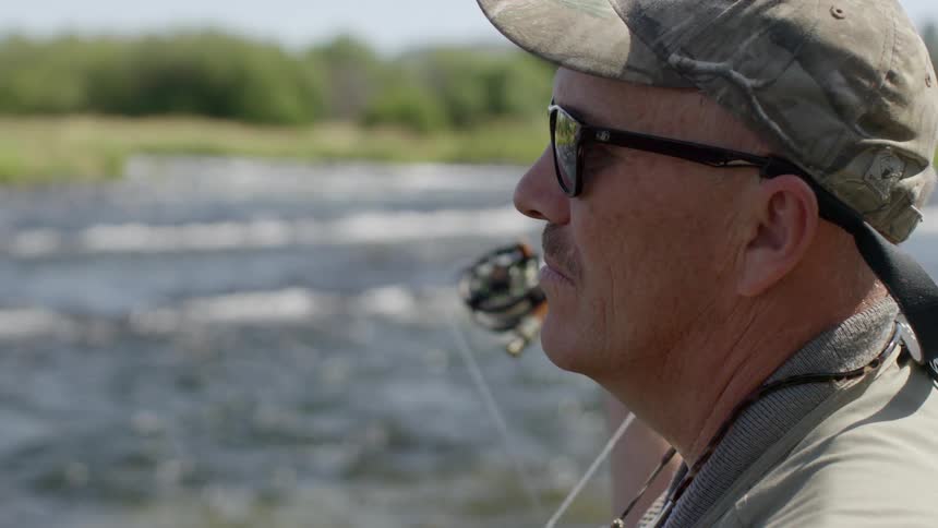 A close shot of a man fly fishing