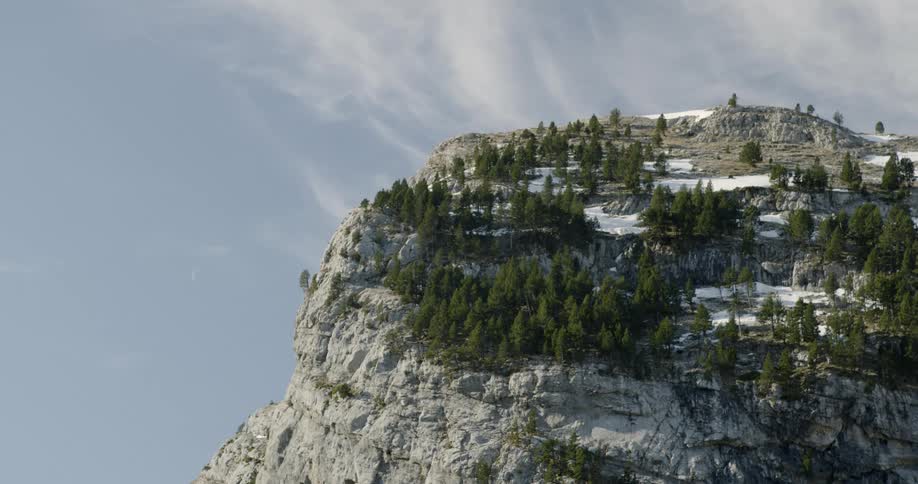 A high area of rock with a very steep side on a sunny day