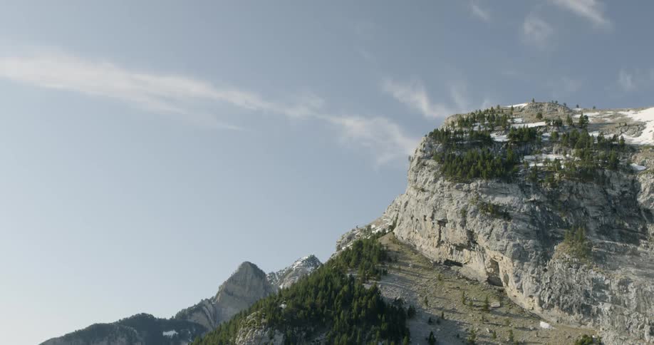 A high area of rock with a very steep side on a sunny day