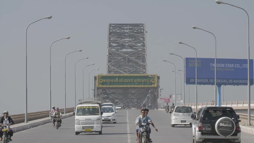 A bridge with vehicles and motorcycles driving on it