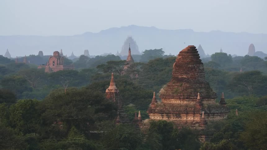 Ancient temples rise above a forested area
