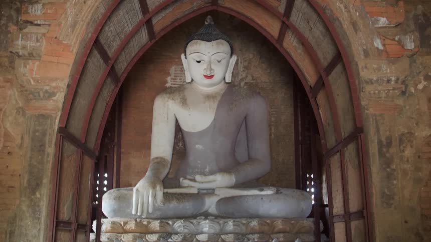 A large buddha statue sits in a building entrance