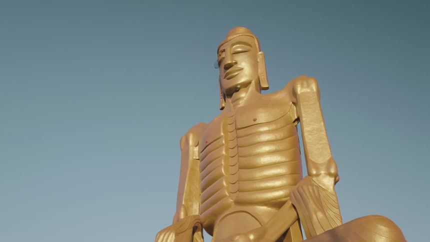 A golden statue stretches into the sky
