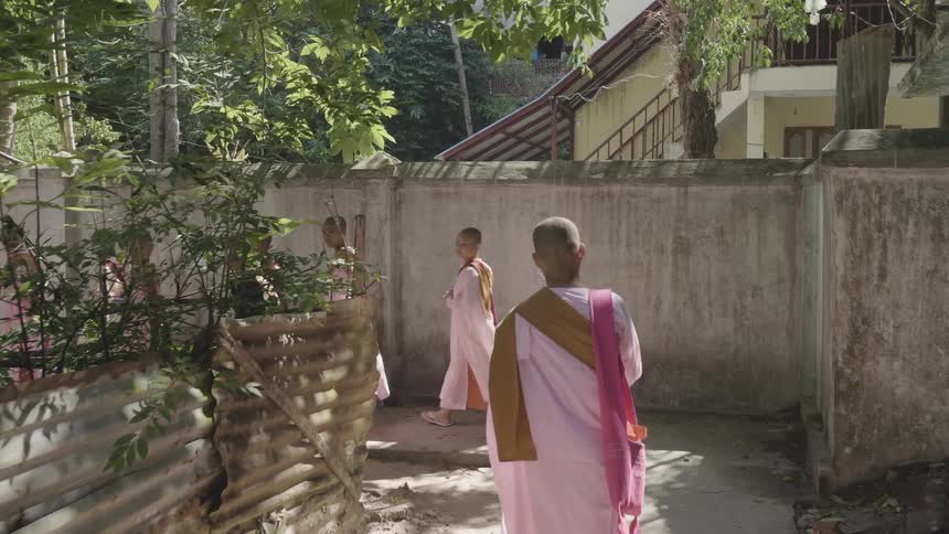 A member of a group of religious men walk on the road in the neighbourhood