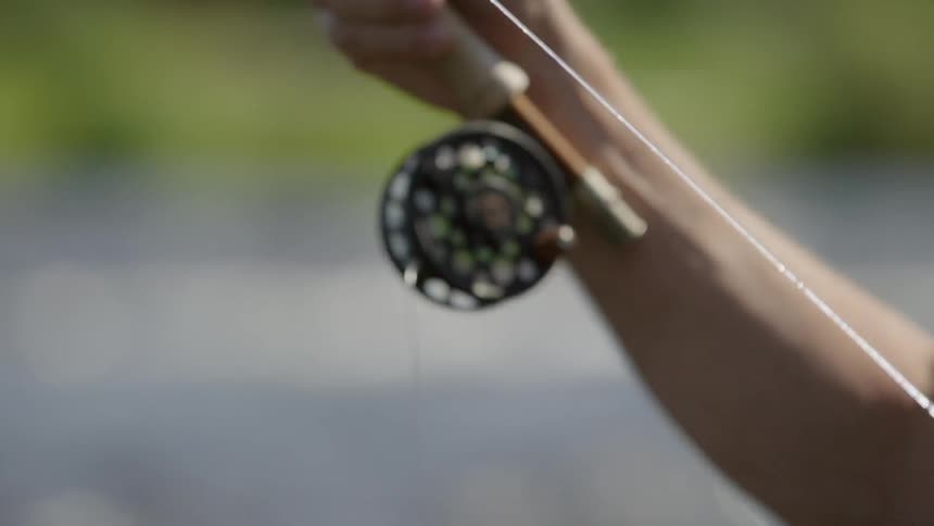 A fisherman holds a fishing pole
