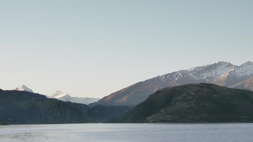 Snow capped mountain ranges next to the tranquil lake