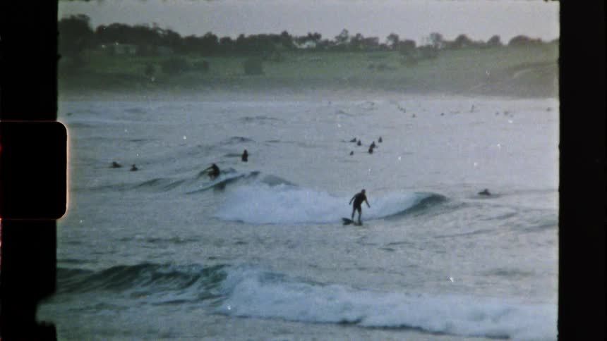 A group of people ride surfboards on ocean waves