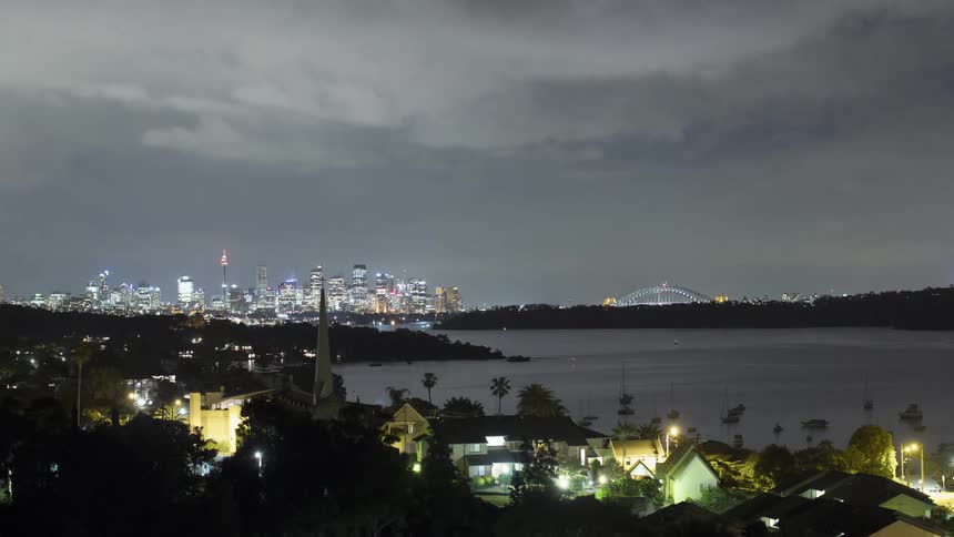 A town near the coast with boats and a city skyline in the background