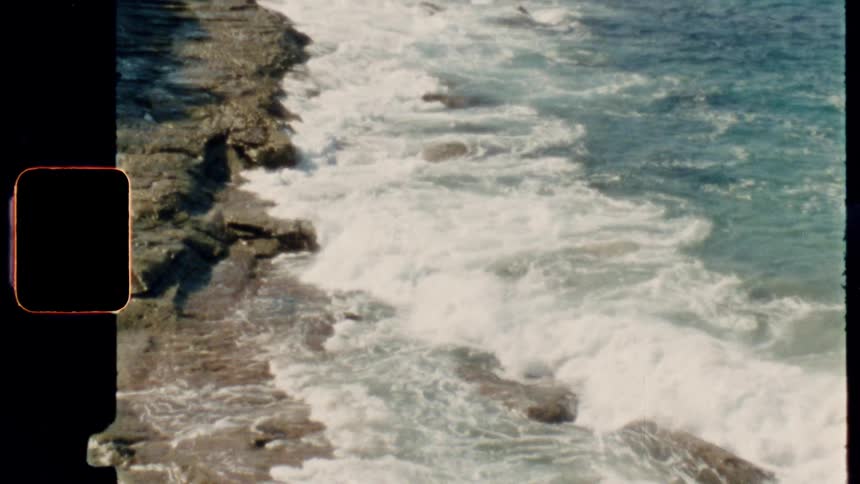 Ocean waves white with foam come to a rocky shore